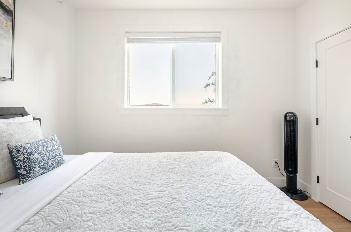 Une chambre à coucher avec un lit, une fenêtre, un radiateur et une porte.