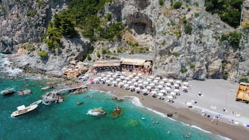 Plage, sable noir, parasols, serviettes de plage