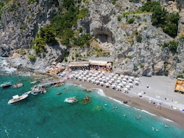 Ubicación a pie de playa, arena negra, sombrillas y toallas de playa