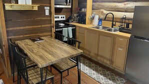 Una cucina compatta con mobili in legno, un frigorifero in acciaio inox, un forno a microonde e un lavandino.