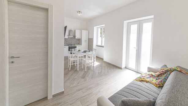 A modern apartment with a dining area, kitchen, and living space. - Agave House (Forio)
