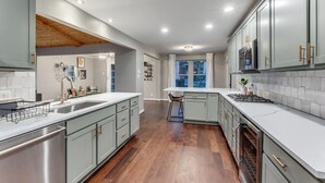 A modern kitchen with a skylight, stainless steel appliances, and light-colored cabinetry. - Heated Pool, Putting Green, Movie Theater and more! 4 bed/3 bath (Dallas)