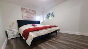 Une chambre à coucher avec un lit, une table de chevet et une fenêtre.