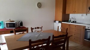 Eine kompakte Küche mit Holzausstattung, einer Mikrowelle, einem Toaster und einem Spülbecken.