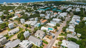 Vista aérea de uma área residencial com casas, estradas e um grande corpo d'água ao fundo.