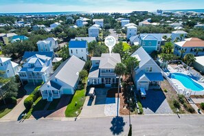Un quartier résidentiel avec des maisons, une piscine et un panneau indiquant « Plage moderne ».