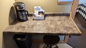 Une petite cuisine équipée d’une machine à café, d’un panier de collations et d’un livre intitulé « The Chippewas Flowage ».