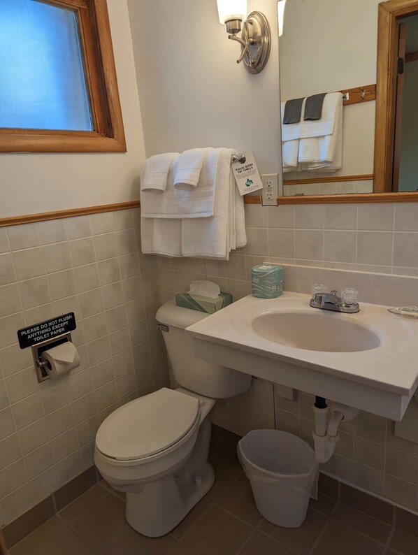 A bathroom with a toilet, sink, and a towel rack with towels. - Chip-Wa Lodging Room 5 (Hunter)