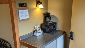 A compact kitchenette with a coffee maker, a sign indicating no smoking, and a WiFi password sign. - Chip-Wa Lodging Room 5 (Hunter)
