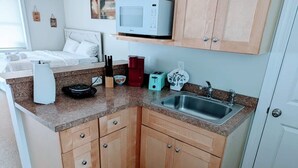 A compact kitchen with a microwave, toaster, and sink. - Perfectly Located Studio in MB (Myrtle Beach)