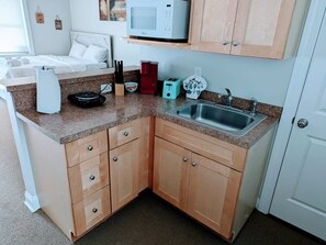 Geladeira, cafeteira/chaleira, talheres/pratos/utensílios de cozinha