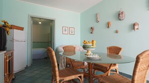 A dining area with wicker chairs, a glass table, and a decorative bowl with a yellow design. - Villa Zio Tore - Bilo by BarbarHouse (Torre Suda)