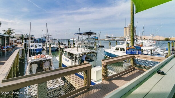 A marina with multiple boats docked, a restaurant with outdoor seating, and a clear view of the water. - Relaxing Apartment Close to the Beach ! (Cape Canaveral)