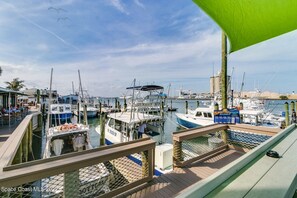 A marina with multiple boats docked, a restaurant with outdoor seating, and a clear view of the water. - Relaxing Apartment Close to the Beach ! (Cape Canaveral)