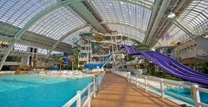 An indoor water park with multiple slides and a large pool area.