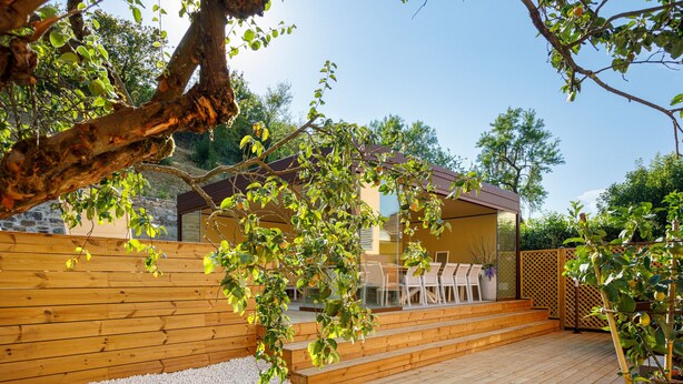 A wooden deck with a seating area and a glass door leading to a building. - Canaiolo holiday home with mini-pool in the center of Greve in Chianti (Greve in Chianti)