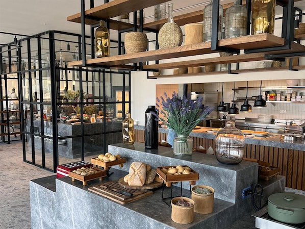 A modern kitchen with marble countertops, wooden shelves, and various kitchen appliances. - King Jason Zante – Designed for Adults (Zakynthos)