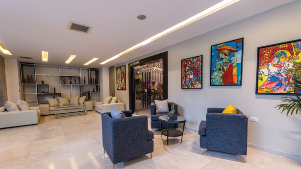 A modern living room with sofas, a coffee table, and artwork on the walls. - Boho Boutique Hotel (Amman)