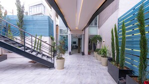 A modern building with a staircase, potted plants, and a clean, tiled floor. - Boho Boutique Hotel (Amman)