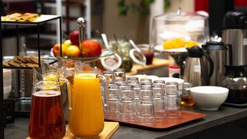Um buffet de café da manhã com diversas opções de comida e bebidas.