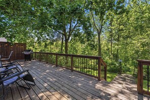 A wooden deck with outdoor furniture, a grill, and a sign indicating a caution area. - Château Ravine, backing onto a beautiful tree-filled ravine (Niagara-on-the-Lake)