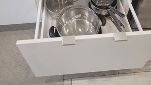 A kitchen drawer containing stainless steel pots and pans. - Cozy and modern bachelor suite with kitchenette and bath  (Guelph)