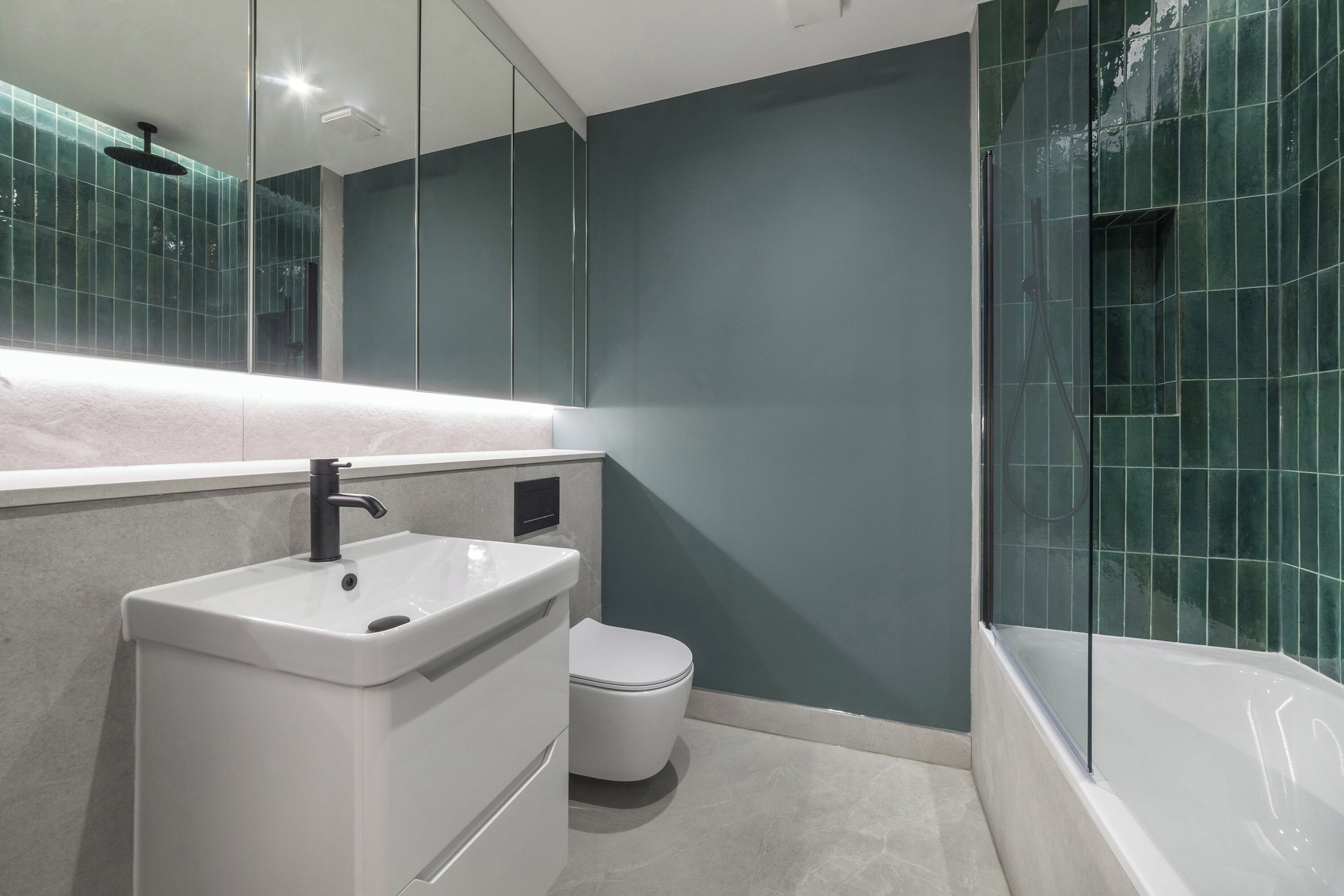 A modern bathroom with a white sink, toilet, and bathtub.