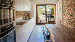 Una cocina con comedor, vistas al exterior y un muro decorado.