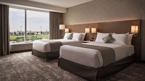 A hotel room with two beds, large windows, and a view of a cityscape and park. - Great Canadian Casino Resort Toronto (Toronto)