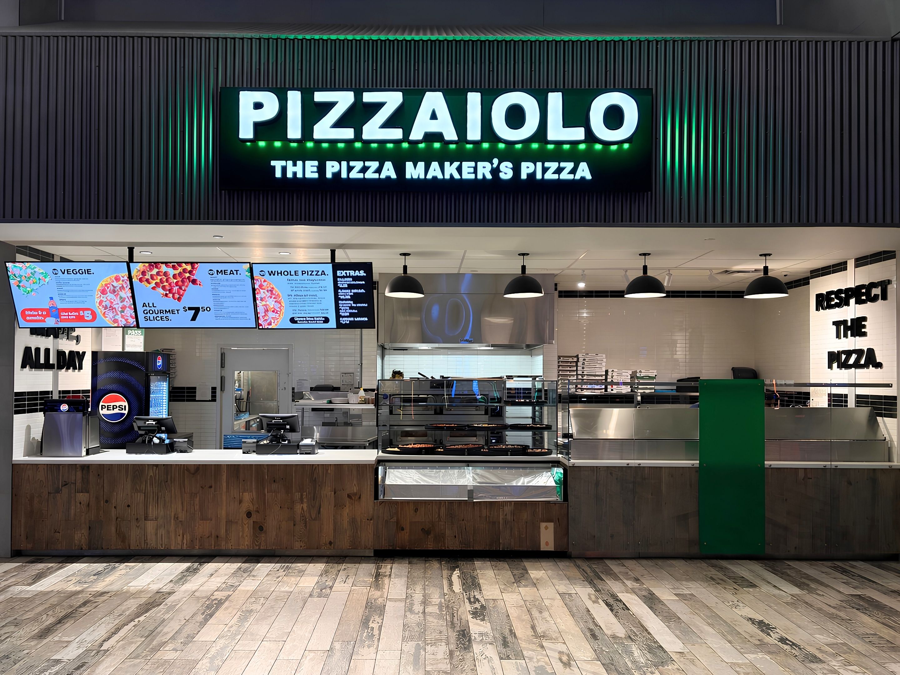 A pizza restaurant with a sign reading 'PIZZAIOLO THE PIZZA MAKER'S PIZZA' and a menu board above the counter.