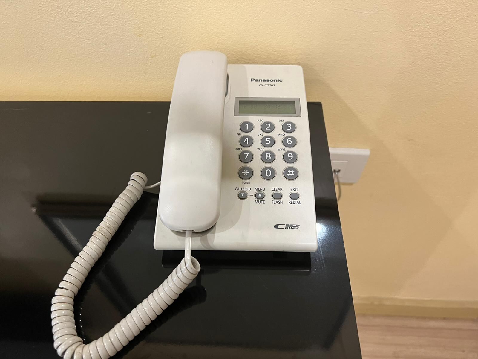 Ein Panasonic Telefon auf einer schwarzen Oberfläche.