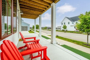 A covered outdoor seating area with red chairs and a wooden ceiling.
