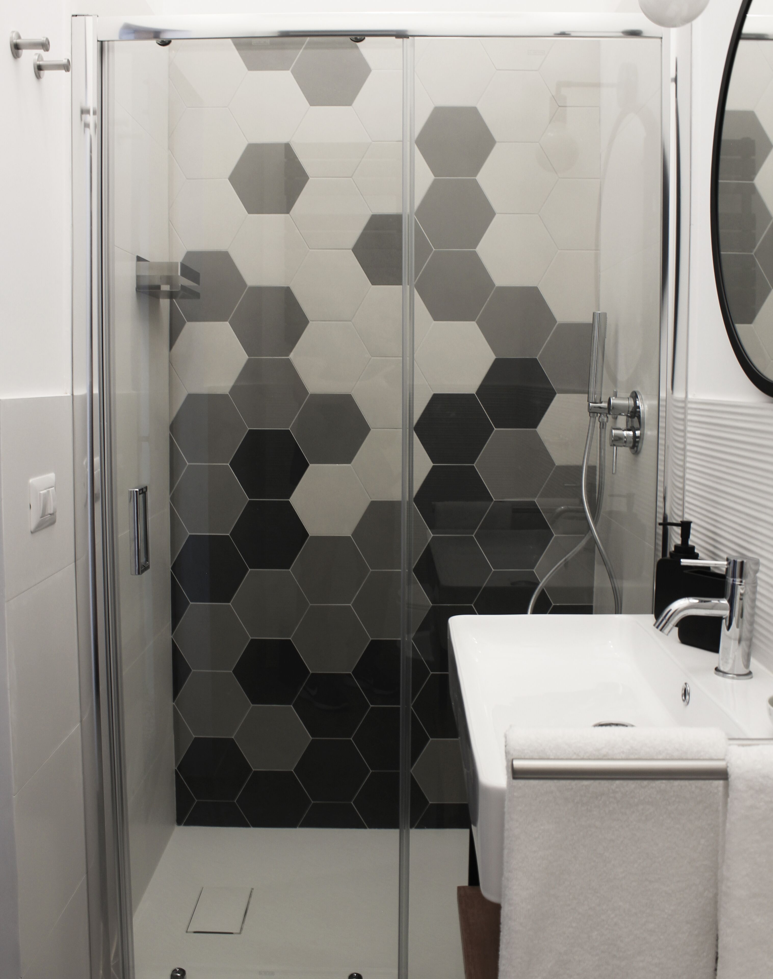 A modern bathroom with a glass shower enclosure and a white sink.