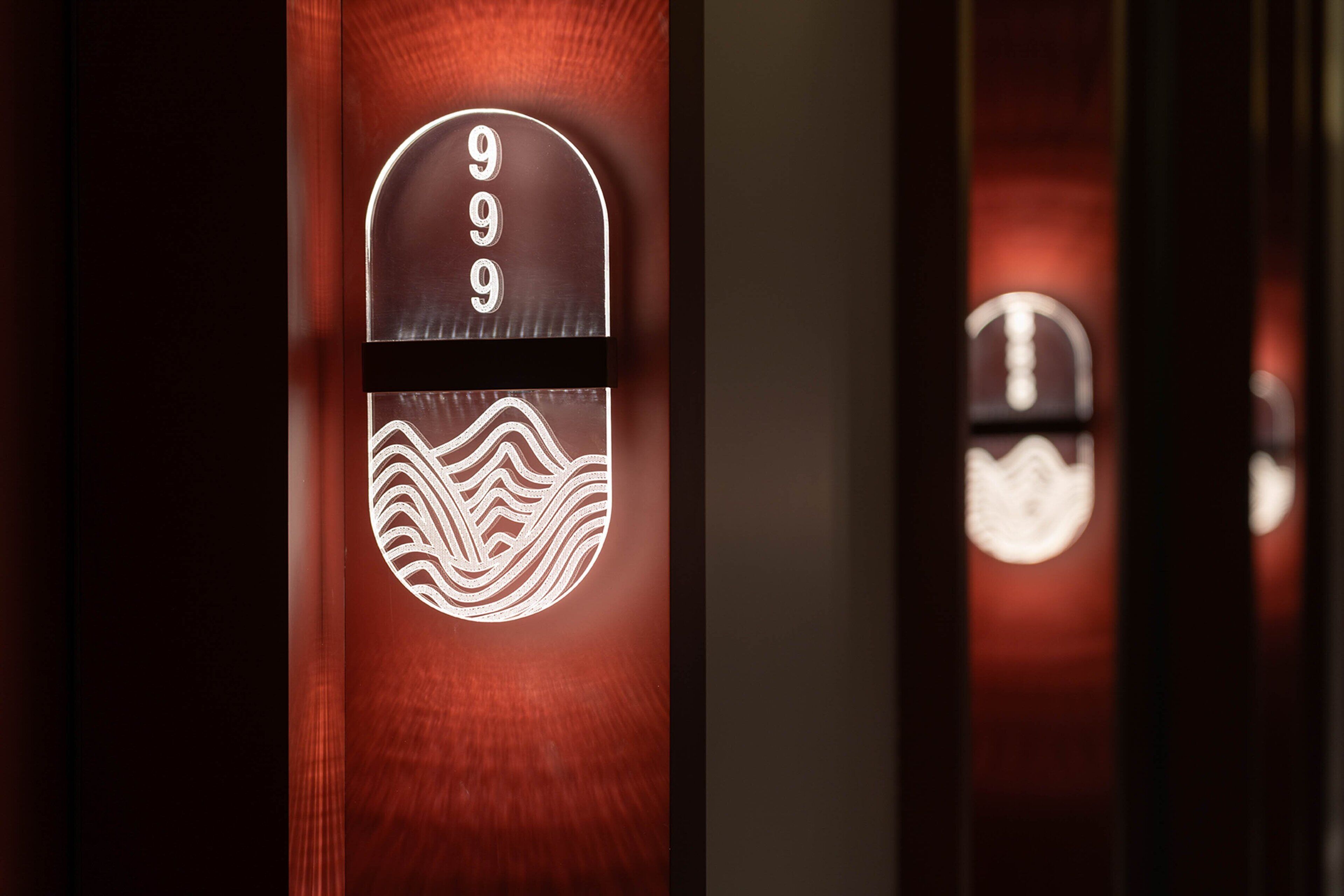 A hotel entrance with a digital keypad displaying the number 999 and a wave pattern.
