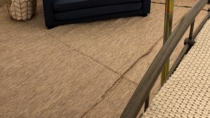 A tent interior with a dark blue sofa, two pillows, and a small woven basket. - Teton View Tent (Tetonia)