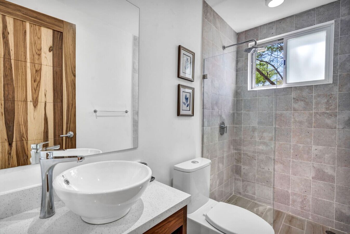 A modern bathroom with a large sink, toilet, and shower.