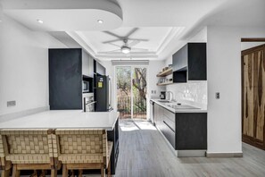 Køleskab, mikrobølgeovn, køkkentøj/tallerkener/redskaber, spisebord