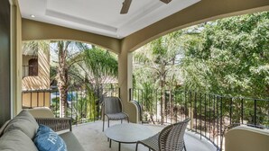 A covered outdoor patio with a sofa, two chairs, and a table. - Gav4: New Condo in Location Walkable to Beach (Tamarindo)