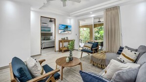 A spacious living room with a ceiling fan, a sofa set, a coffee table, and a dining area. - Gav4: New Condo in Location Walkable to Beach (Tamarindo)