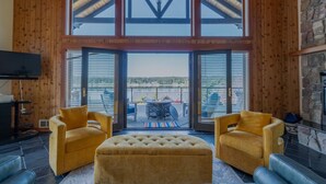 A spacious living room with a large window, a fireplace, and a view of the outdoors. - Private beach luxury home sleeps 12, Shelton, WA (Shelton)