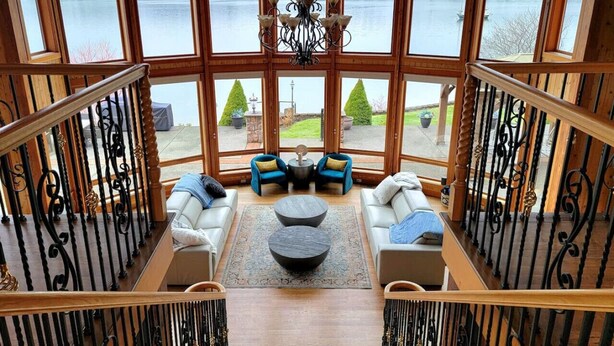 A spacious balcony with a view of a lake, furnished with sofas and a coffee table. - Private beach luxury home sleeps 12, Shelton, WA (Shelton)