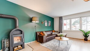 Een moderne woonkamer met een open haard, een bank, een salontafel en een groot raam.