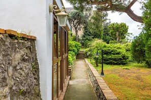 Un chemin menant à un bâtiment doté d’un mur en pierre et de portes en bois.