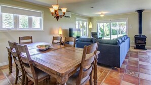 A dining area with a wooden table and chairs, a sofa, and a fireplace.