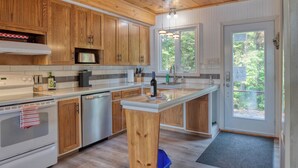Une cuisine moderne avec des meubles en bois, des appareils en acier inoxydable et un grand îlot central.