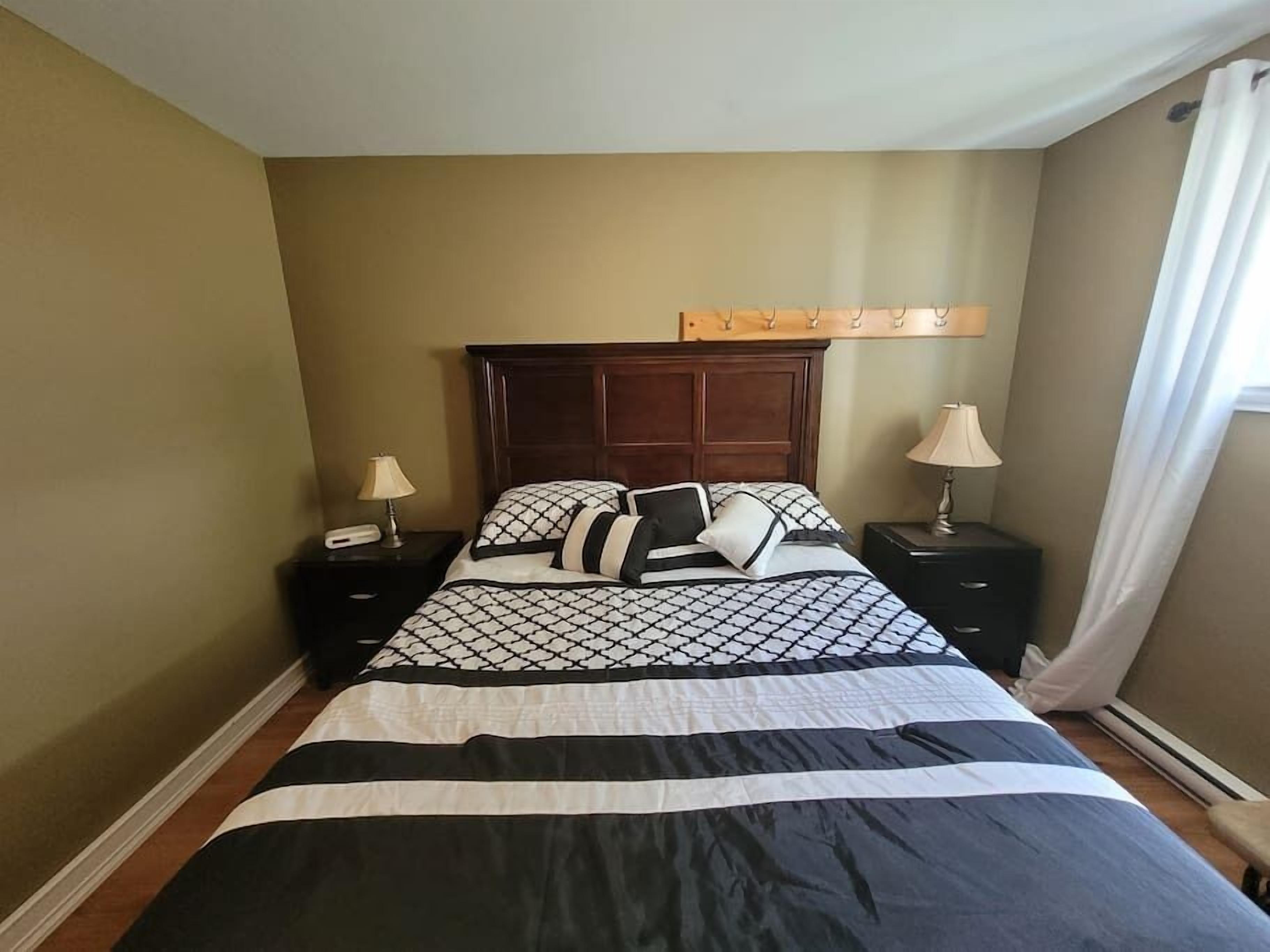 A neatly arranged bedroom with a large bed, two bedside tables, and a headboard.