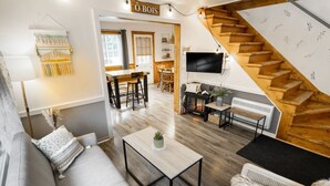Ein modernes Wohnzimmer mit einer Couch, einem Couchtisch und einer Treppe.