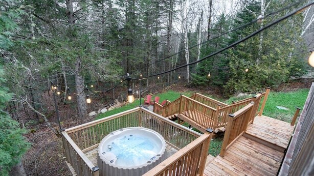 Ein Whirlpool auf einer Holterrasse, umgeben von einem Wald.