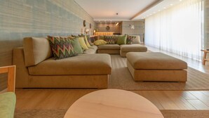 Una sala de estar moderna con un sofá modular, otomanas y una mesa de centro redonda.