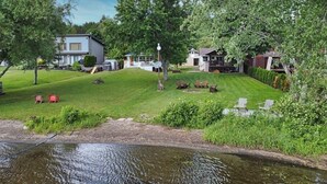 Een woonwijk met een gazon, een vijver en huizen op de achtergrond.